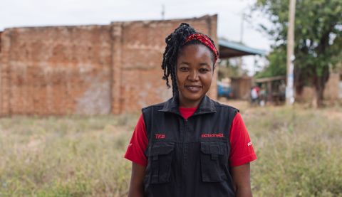 A woman in ActionAid vest smiling at camera