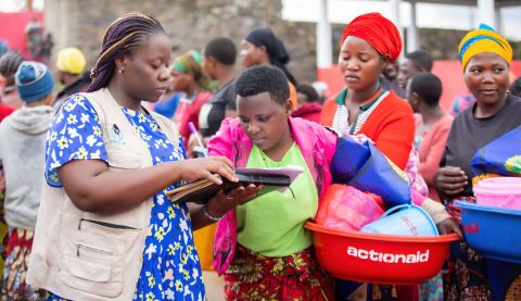 A woman distributing hygiene kits to displaced women in the DRC