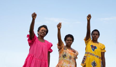 Three women holding fists up in the air