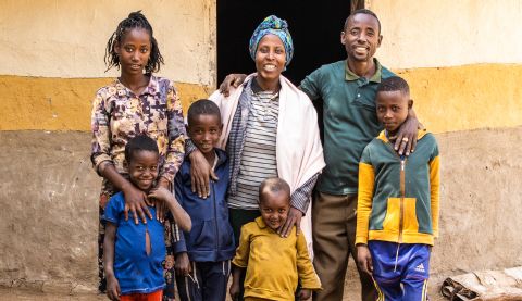 a family posing for a photo in front of their house