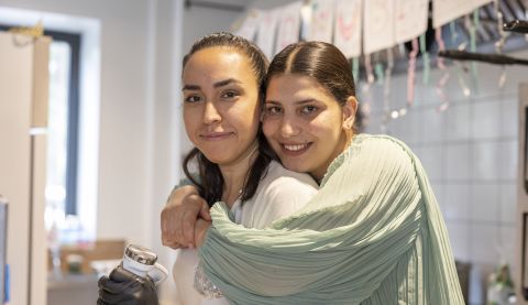Woman hugging her friend and looking into camera