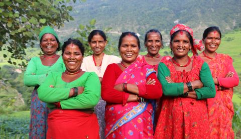 Group of Nepalese women standing with their arms folded and smiling.
