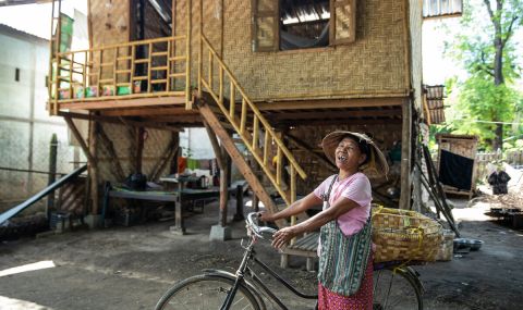 Woman on a bike in front of her house