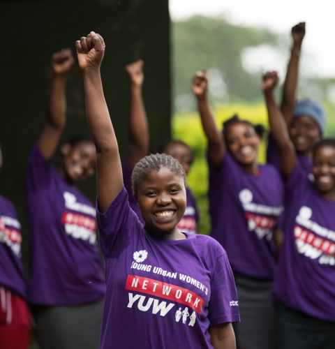 Women in purple Tshirts raising their fists to the sky