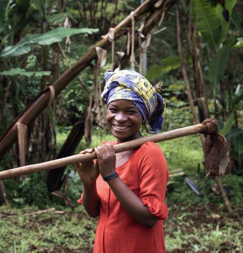 Farmer holding a spade and posing for the camera.