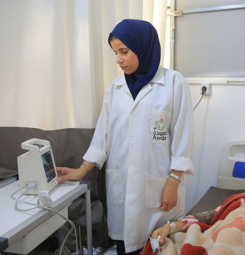 A nurse in uniform standing in a hospital
