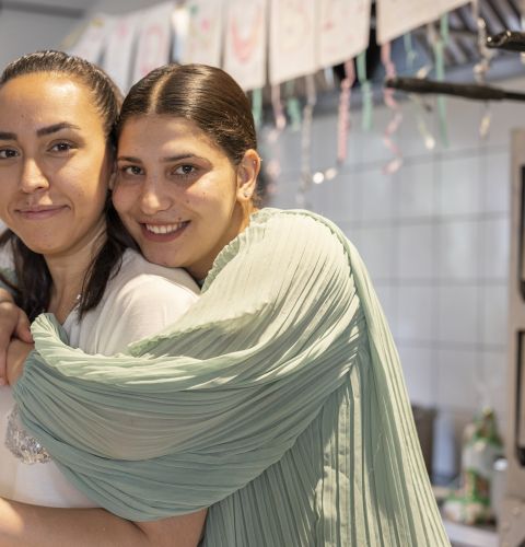Woman hugging her friend and looking into camera