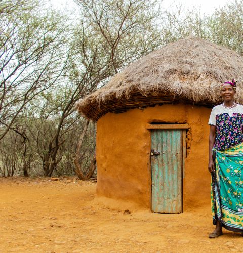 woman standing in front of a hut
