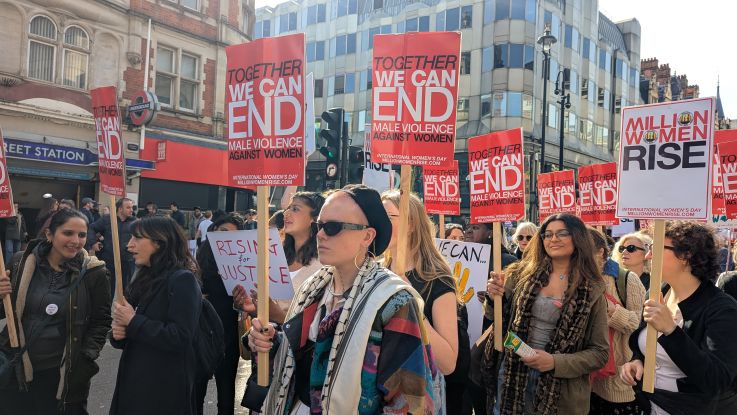 ActionAid at women's march holding placards