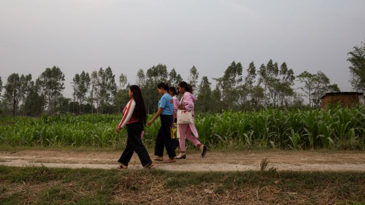 Women in Nepal, walking in a field