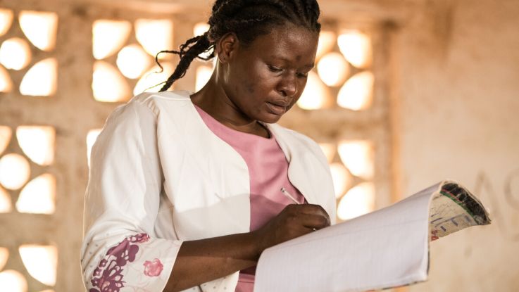 A teacher signing a copy book