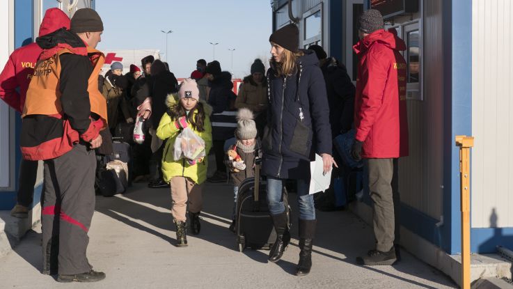 Families being ushered by officials as they escape war