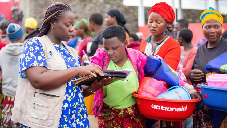 A woman distributing hygiene kits to displaced women in the DRC