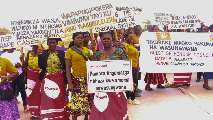 women at a march holding signs