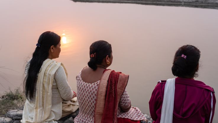 women looking over at the river with their backs to us
