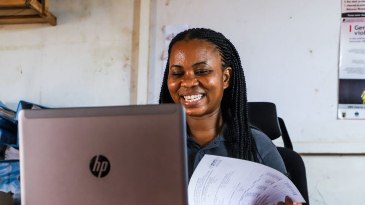 A woman sitting at a desk in front of her laptop.
