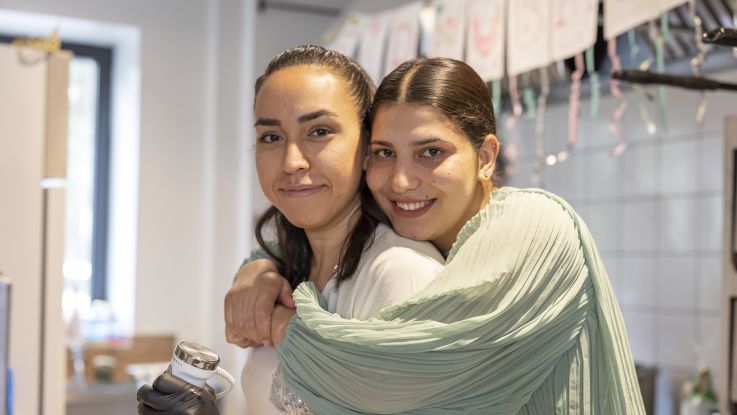 Woman hugging her friend and looking into camera