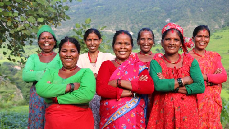 Group of Nepalese women standing with their arms folded and smiling.